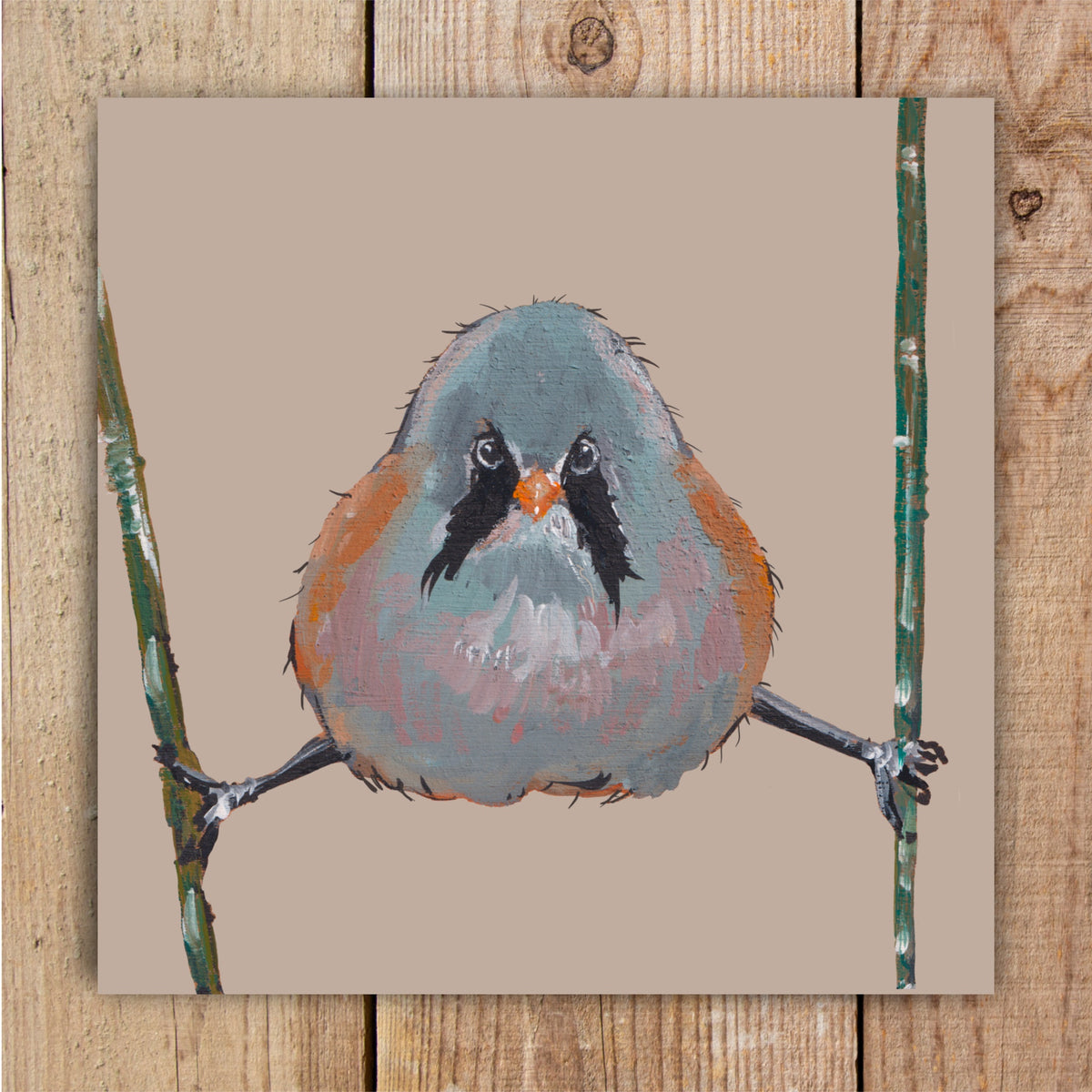A square eco-friendly greetings card featuring an original wildlife painting of a bearded bit with brown plumage and a distinctive black drooping moustache, comically perched legs-apart on reeds against a warm beige background.