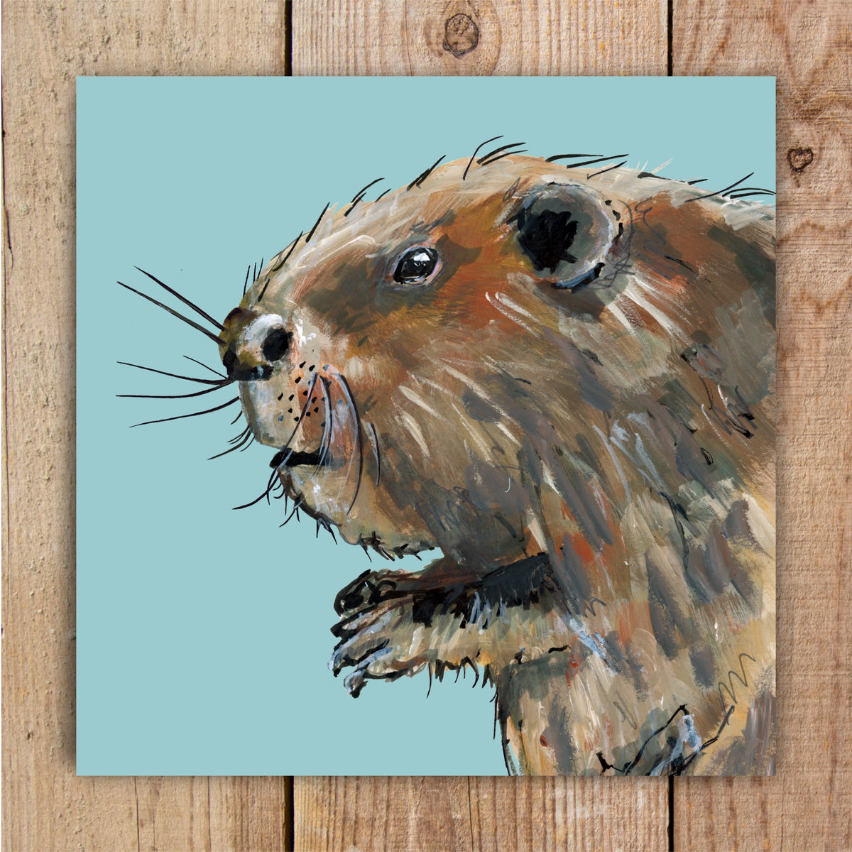 An eco-friendly greetings card featuring a painted portrait of a beaver in shades of brown, black and tan against a sky blue background.